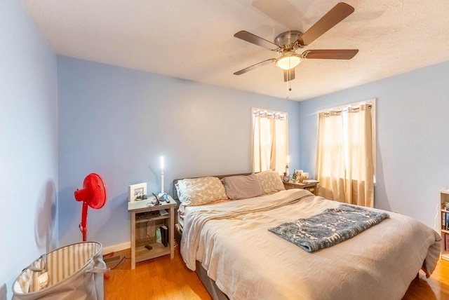 bedroom featuring baseboards, a ceiling fan, and light wood-style floors