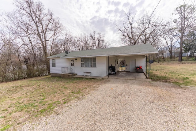 view of front of house featuring a front yard, a carport, and dirt driveway