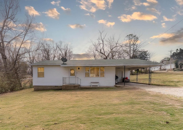 view of front of property with a yard, a carport, and driveway