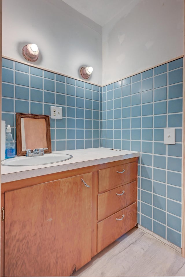 bathroom featuring vanity, tile walls, and wood finished floors