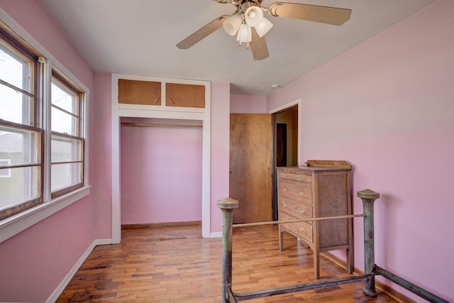 bedroom with wood finished floors, baseboards, a closet, and ceiling fan