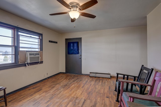 sitting room with ceiling fan, baseboards, cooling unit, wood finished floors, and a baseboard radiator