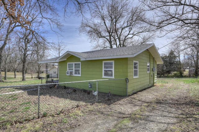 view of front of home featuring cooling unit, a shingled roof, driveway, and fence