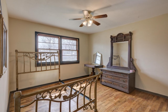 bedroom featuring light wood finished floors, a ceiling fan, and baseboards