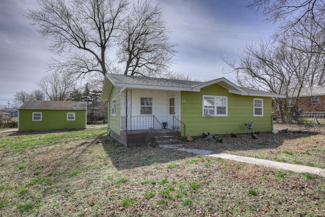 bungalow-style house featuring an outdoor structure and fence