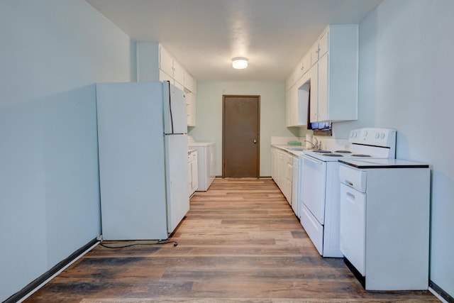 kitchen with white appliances, white cabinetry, light wood-type flooring, and light countertops