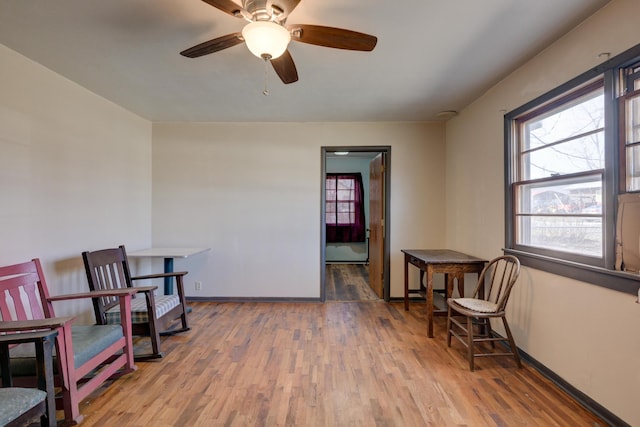 sitting room featuring ceiling fan, baseboards, and wood finished floors