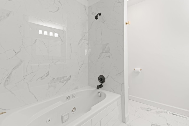 bathroom featuring a combined bath / shower with jetted tub, baseboards, and marble finish floor