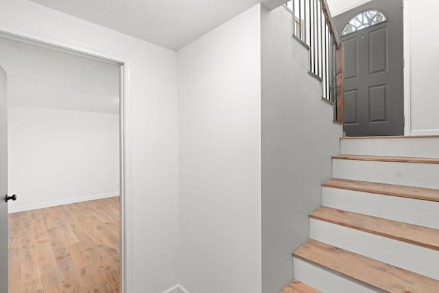 stairs featuring baseboards and wood finished floors