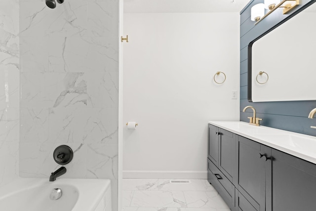 bathroom featuring marble finish floor, a sink, shower / tub combination, double vanity, and baseboards