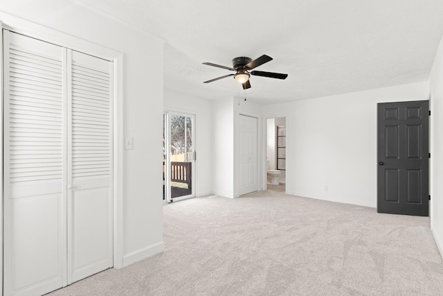 unfurnished bedroom featuring access to exterior, a closet, carpet, baseboards, and ceiling fan