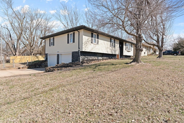 view of side of home featuring a yard, fence, a garage, and driveway