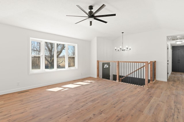 unfurnished room with visible vents, wood finished floors, baseboards, and vaulted ceiling