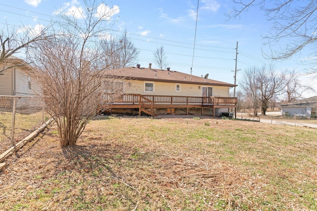 rear view of property featuring a lawn, a deck, and fence