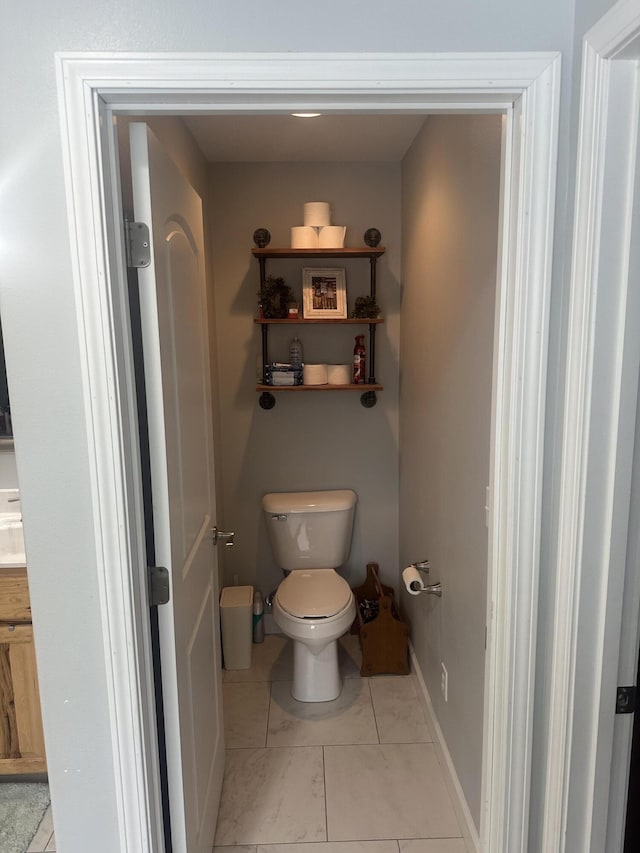 bathroom with toilet and baseboards