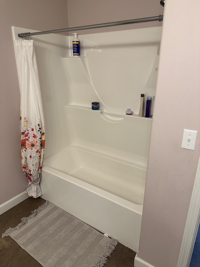 bathroom with baseboards and shower / bathtub combination with curtain