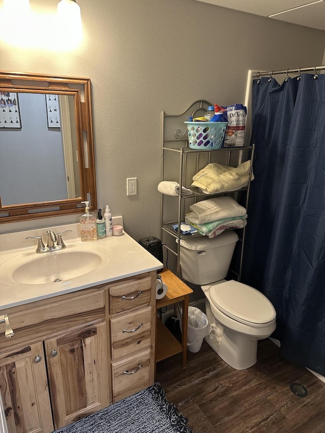 full bath with a shower with curtain, toilet, wood finished floors, and vanity