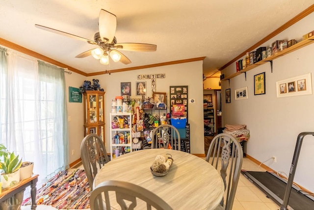 dining room featuring light tile patterned floors, baseboards, ceiling fan, and crown molding