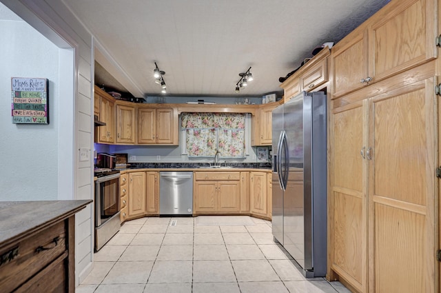 kitchen featuring light brown cabinetry, a sink, under cabinet range hood, stainless steel appliances, and light tile patterned floors