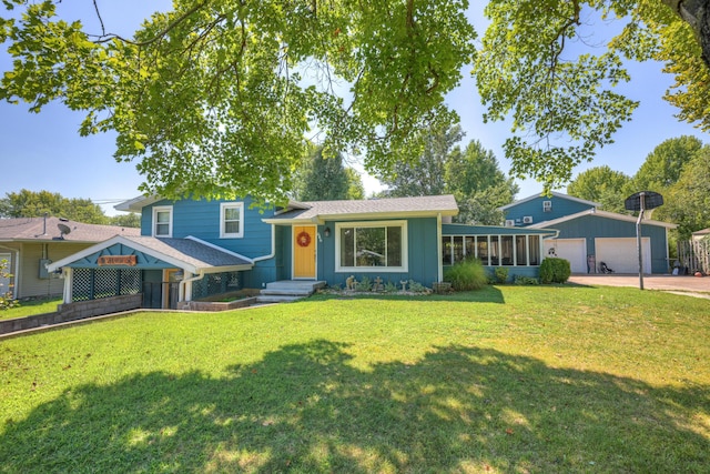 tri-level home with an outdoor structure, driveway, a front yard, and a sunroom