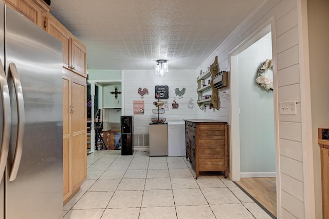 kitchen with light tile patterned flooring and freestanding refrigerator