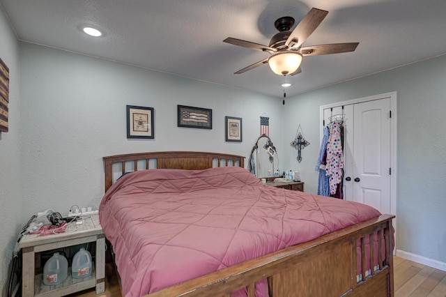 bedroom with baseboards, recessed lighting, wood finished floors, a closet, and a ceiling fan