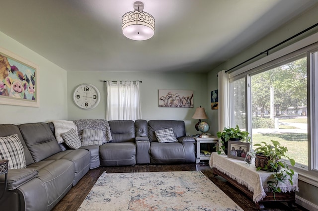 living room with dark wood finished floors and a healthy amount of sunlight