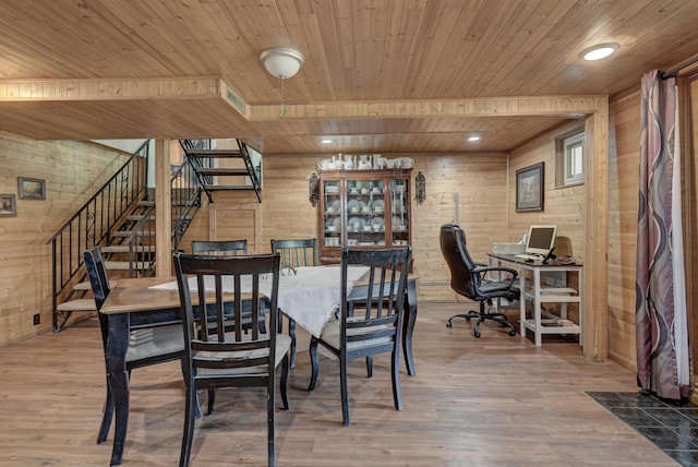 dining room with stairway, wooden walls, wood ceiling, and wood finished floors