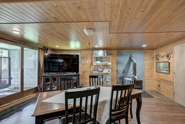 dining room featuring wooden ceiling, wooden walls, and wood finished floors