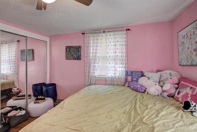 bedroom featuring a closet, a textured ceiling, and a ceiling fan