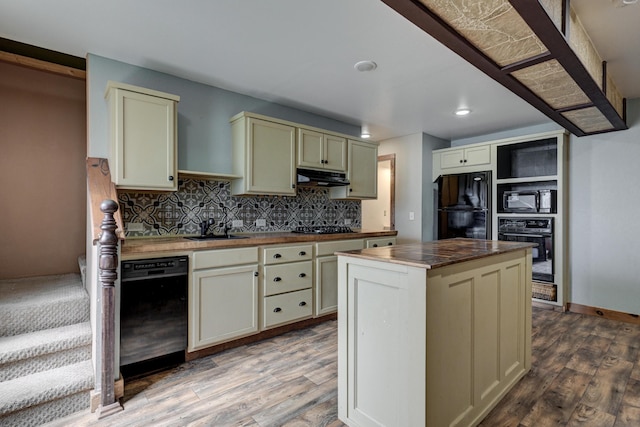 kitchen with cream cabinetry, black appliances, wood finished floors, range hood, and butcher block counters