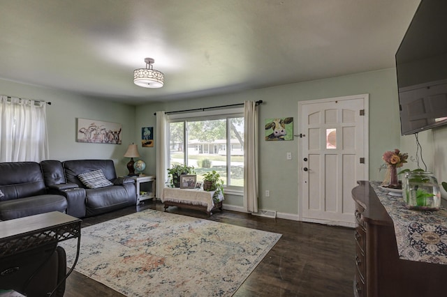 living room featuring visible vents, baseboards, and dark wood-type flooring