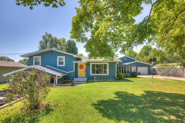 tri-level home with an outdoor structure, a front yard, and fence