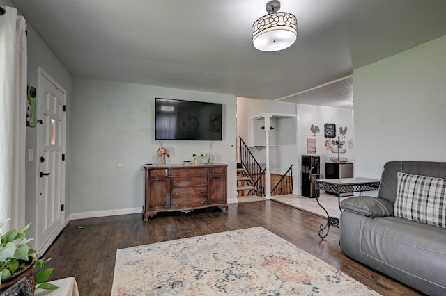 living area with stairway, baseboards, and wood finished floors