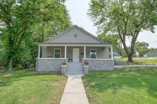 view of front facade with stone siding, a porch, and a front lawn