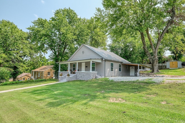 view of front facade featuring an outbuilding, a porch, and a front yard