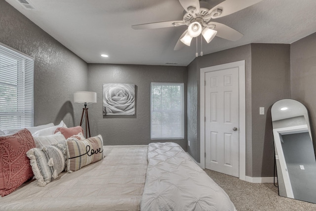 bedroom featuring visible vents, arched walkways, carpet, baseboards, and a textured wall