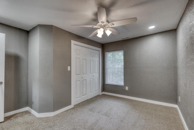 unfurnished bedroom with carpet flooring, a textured wall, and baseboards