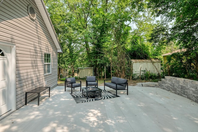 view of patio / terrace with an outbuilding, fence, a shed, and an outdoor hangout area