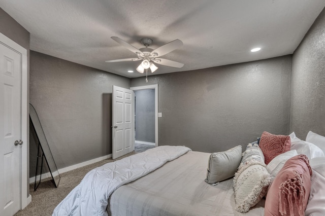 bedroom with ceiling fan, baseboards, a textured wall, and carpet floors