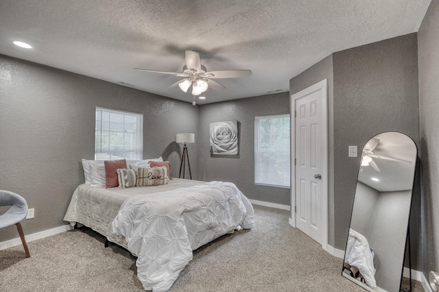 carpeted bedroom featuring a textured ceiling, baseboards, and a textured wall