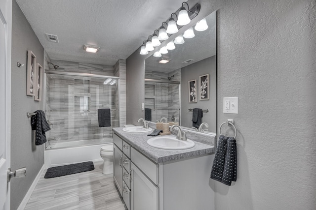 full bathroom featuring a textured ceiling, a textured wall, visible vents, and a sink