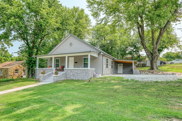 view of front of property featuring an attached carport, a porch, driveway, and a front yard