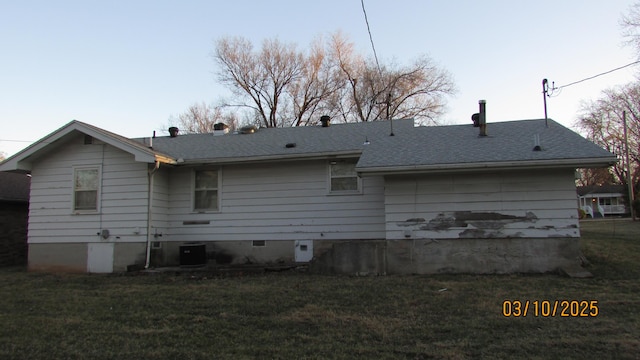 back of property featuring crawl space, a lawn, central AC unit, and a shingled roof