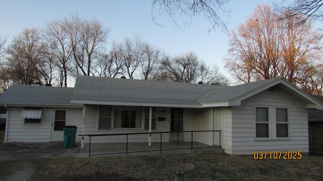 ranch-style home featuring covered porch and a shingled roof