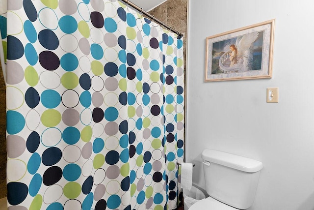 full bathroom featuring toilet and a shower with shower curtain