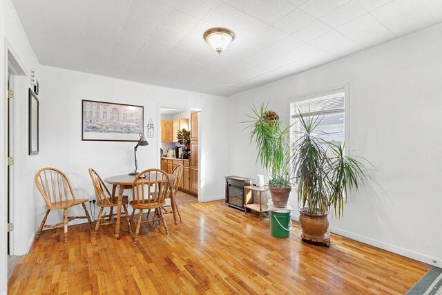 dining area with baseboards and light wood-type flooring