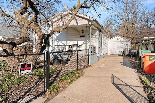 view of home's exterior featuring fence, concrete driveway, an outdoor structure, a garage, and a gate