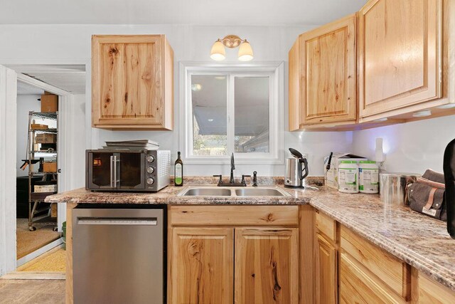 kitchen with light brown cabinetry, appliances with stainless steel finishes, light stone countertops, and a sink