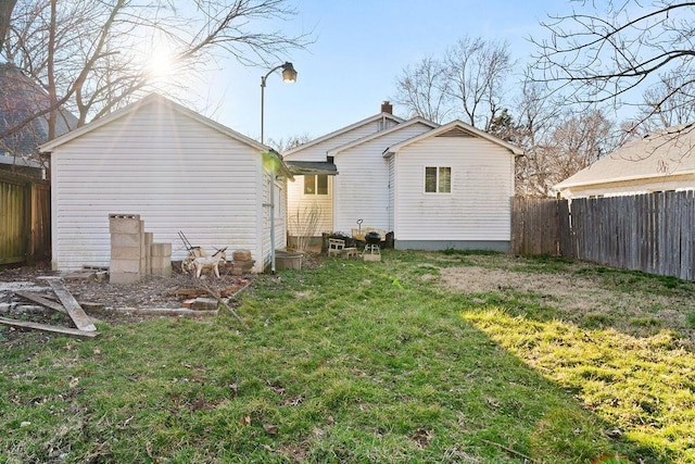 back of property with a lawn and a fenced backyard